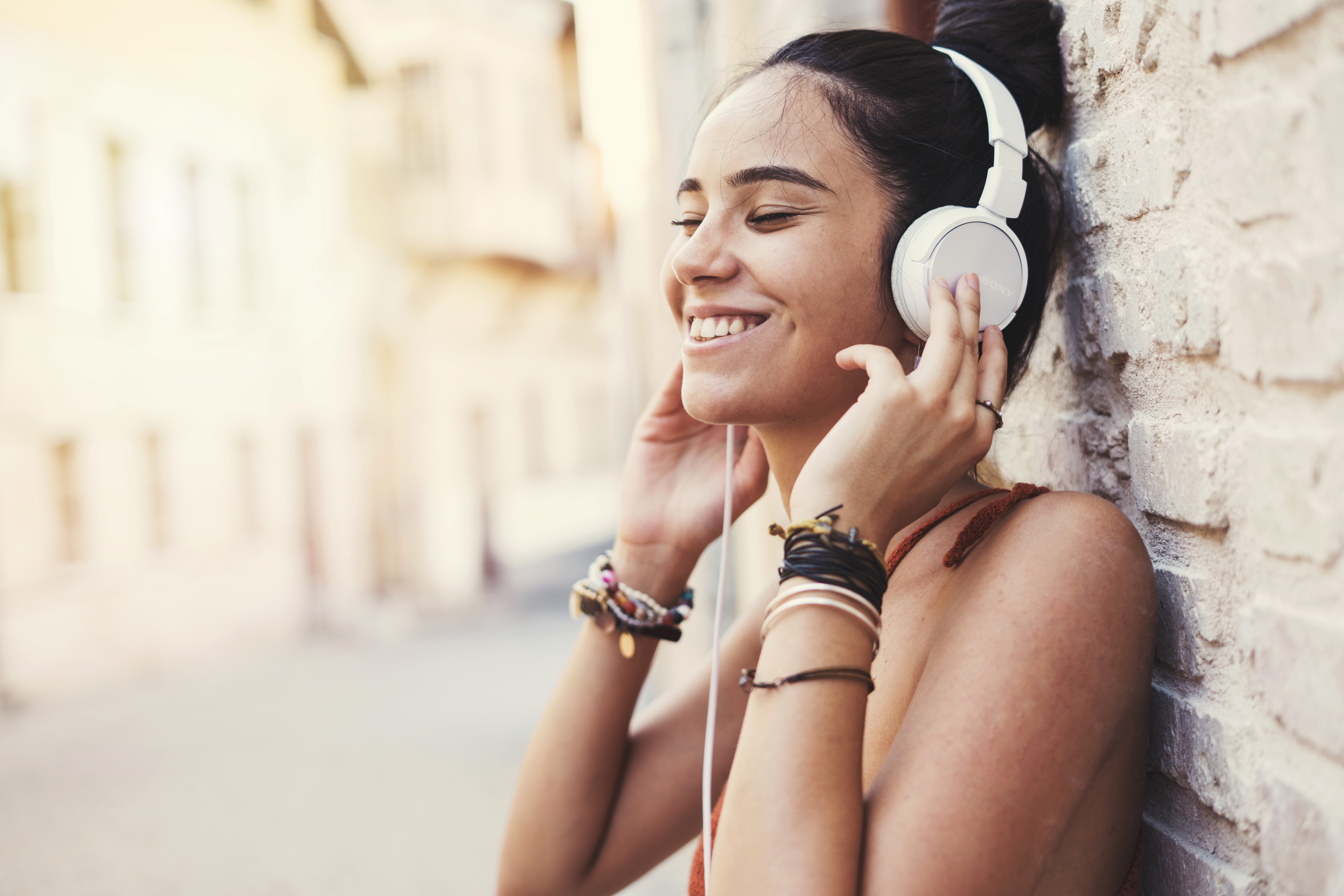 girl listening to noise canceling headphones, happy