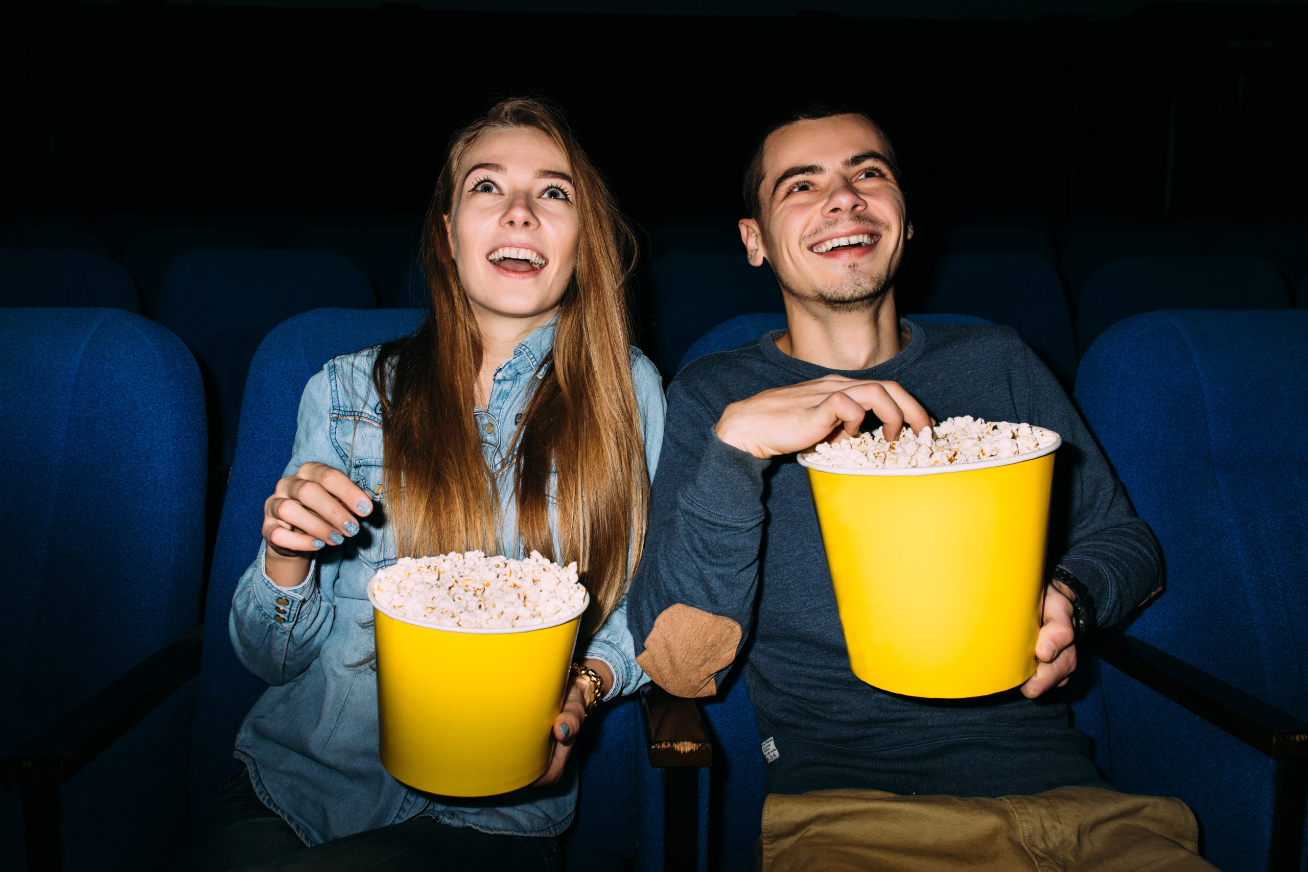 couple enjoying movie in home theater with popcorn