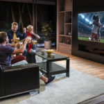 Group of men watch sports on TV