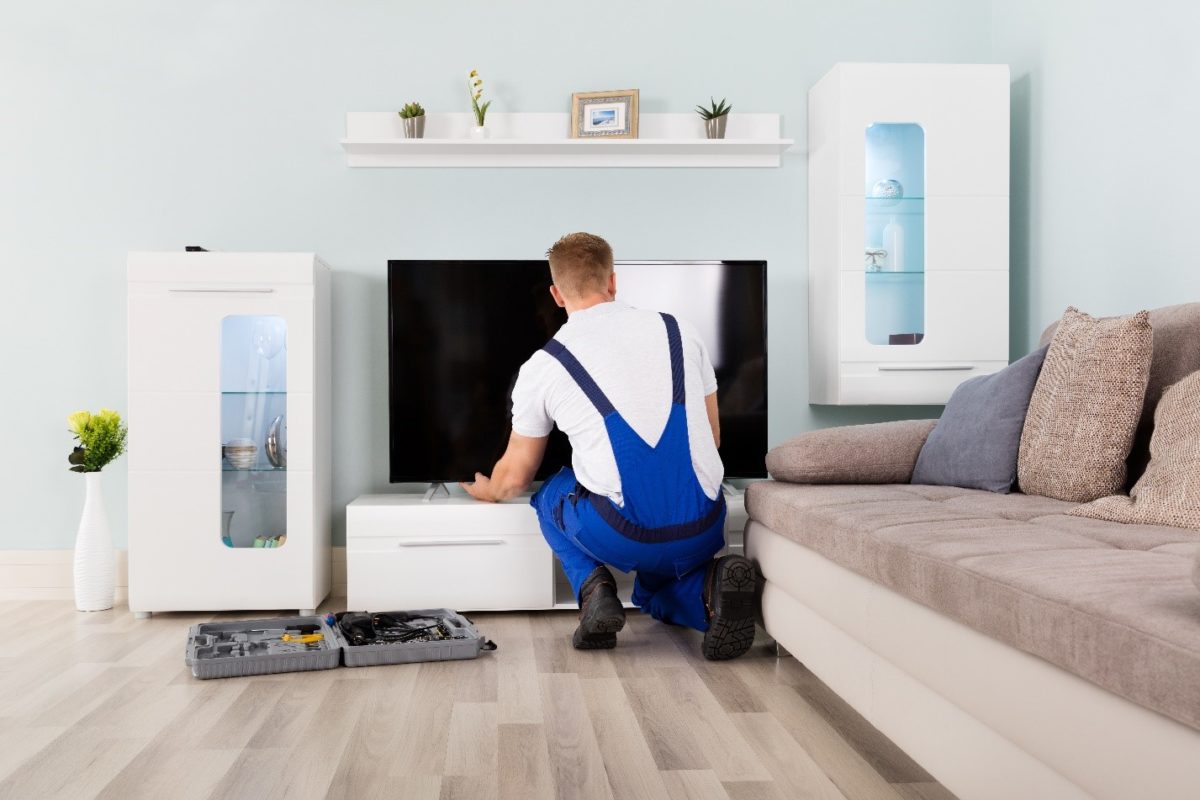 A worker installing a home theater system in a smart home.